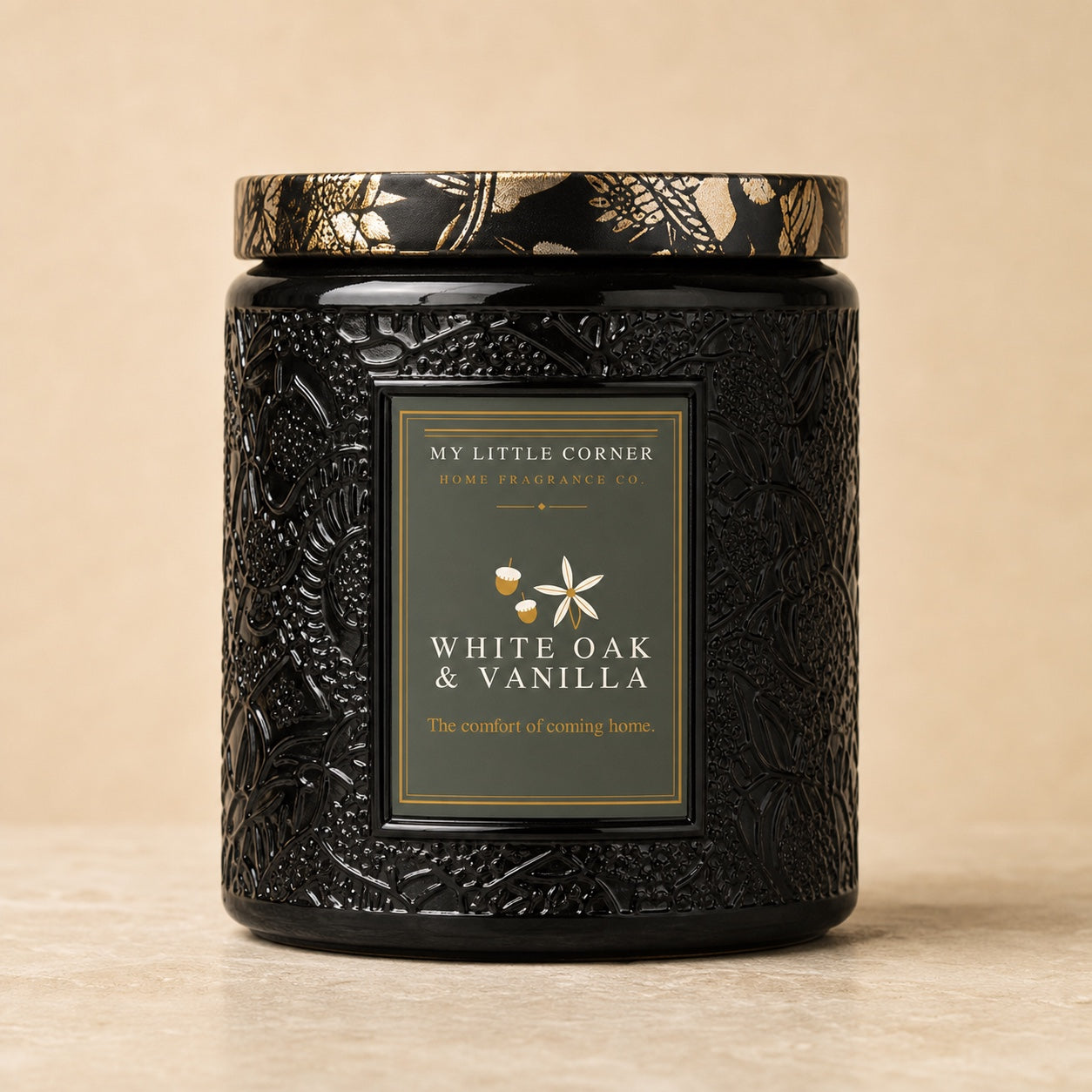A black textured jar candle with a gold and black patterned lid, featuring a front label that reads 'MY LITTLE CORNER HOME FRAGRANCE CO. WHITE OAK & VANILLA'.